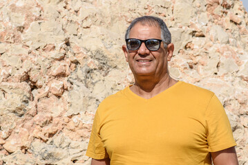 Fototapeta premium Optimistic elderly man standing and smiling outdoor. Close-up portrait of happy senior man looking in camera.