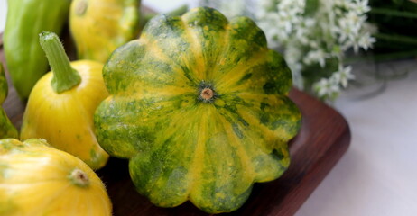 fresh squash vegetable of different shades close-up on a wooden board selective focus. 