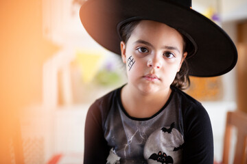 Portrait of caucasian small child dressed up as a witch for Halloween party. Space for text.