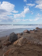 Fototapeta na wymiar Olas bravas en el mar en un día de verano. Playa solitaria y tranquila