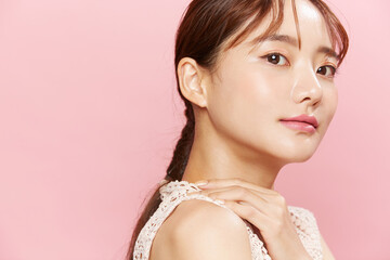 ドレスを着た若い女性のピンク背景のビューティーポートレート
