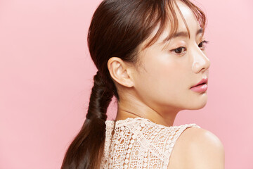 ドレスを着た若い女性のピンク背景のビューティーポートレート