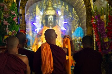 Myanmar. Yangon. Monks front of a Buddha at Shwedagon Pagoda