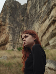 Red-haired woman in the mountains rocks nature romance