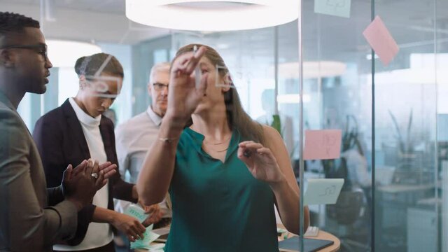 business team meeting using sticky notes brainstorming colleagues working on problem solving strategy writing on glass whiteboard thinking of solution for project in office