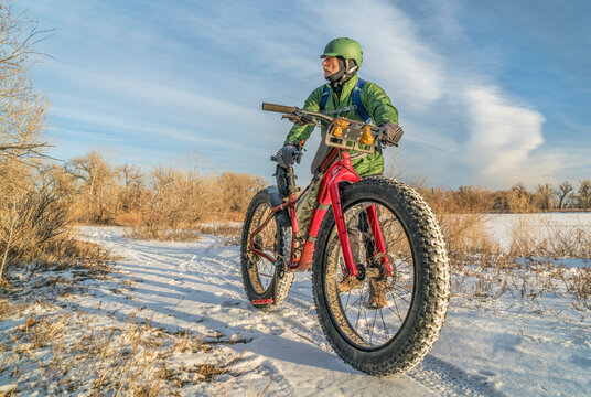 senior cyclist with a fat mountain bike in winter, cold day in Colorado