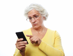 Senior woman wearing yellow sweater and glasses using smart phone isolated on white