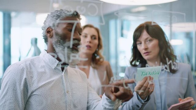 business people using sticky notes mature team leader man brainstorming with colleagues working on solution discussing strategy for project deadline teamwork in office management meeting 4k