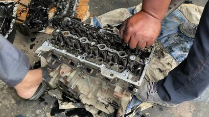 Mechanic are removing valve and rocker arm from the engine