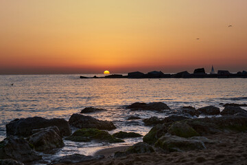 Fototapeta na wymiar sailing boat on the horizon near to the sun at sunset barcelona
