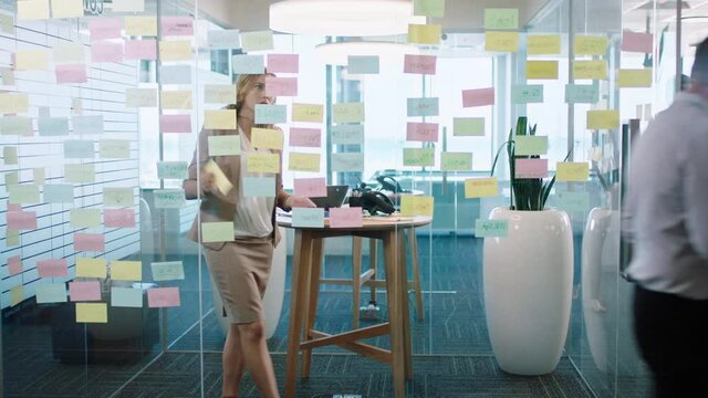 beautiful business woman using sticky notes brainstorming ideas planning strategy problem solving with creative mind map working on solution in office 4k