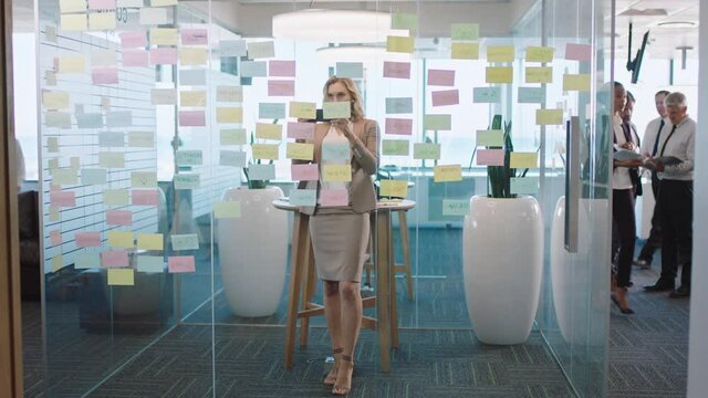 beautiful business woman using smartphone taking photo of sticky notes proud of successful problem solving strategy ideas with creative mind map working in office 4k