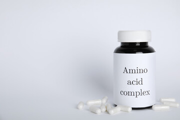Amino acid complex and pills on white background. Space for text