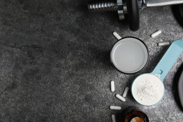 Obraz na płótnie Canvas Amino acid shake, powder, pills and dumbbell on grey table, flat lay. Space for text