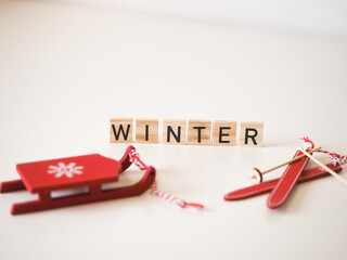 Winter - napis na drewnianych kostkach, zima, sanki i narty  - obrazy, fototapety, plakaty