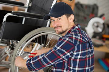 man using pliers to service the brakes on a wheelchair