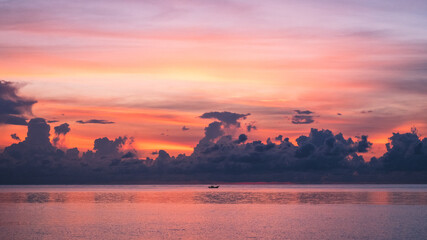 Scenic island's dawn view at peaceful bay against dramatic sunrise colorful cloud sky with lonely fishing boat Koh Samui Island, Thailand. Minimal panorama background with copy space.