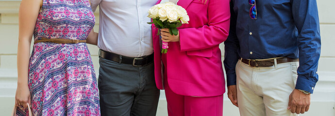 People's bodies and legs stand together. Holiday, wedding, family.