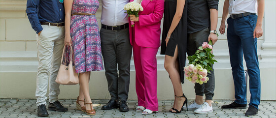 People's bodies and legs stand together. Holiday, wedding, family.