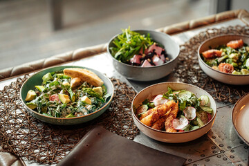 Table served with variety of different gourmet salad bowls