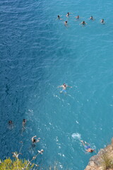 Gruppo di persone nuotano felici in mezzo al mare azzurro e calmo - Ripresa aerea dall'alto con Drone