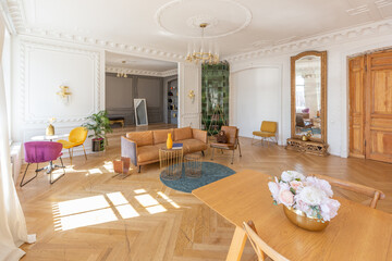 luxury interior of a spacious apartment in an old 19th century historical house with modern furniture. high ceiling and walls are decorated with stucco