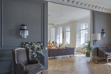 luxury interior of a spacious apartment in an old 19th century historical house with modern furniture. high ceiling and walls are decorated with stucco