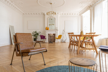 luxury interior of a spacious apartment in an old 19th century historical house with modern furniture. high ceiling and walls are decorated with stucco