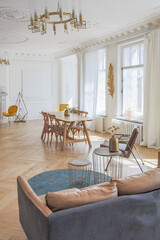 luxury interior of a spacious apartment in an old 19th century historical house with modern furniture. high ceiling and walls are decorated with stucco