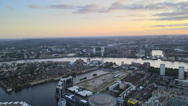 evening cityscape of a river calmly flowing through large town. Colourful sky