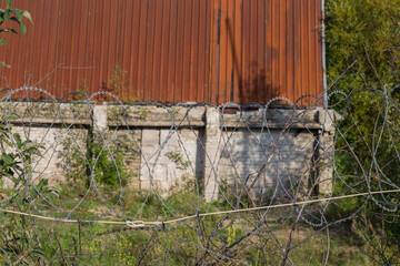 old industrial building surrounded by barbed wire 