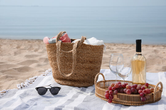 Bag, Blanket, Wine And Other Stuff For Beach Picnic On Sandy Seashore