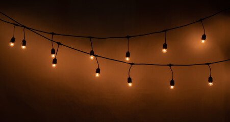 Garlands of lamps over dark texture