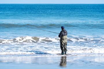fisherman on the beach in the morning fishing