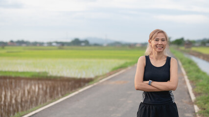 Portrait young attractive smiling fit woman after workout sport exercises outdoors on a background of rice field. Healthy lifestyle well being wellness happiness concept