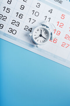Alarm clock and calendar on a blue background