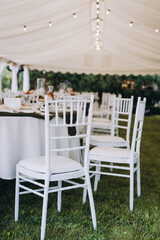 A summer tent with tables, food  and chairs on the wedding day
