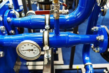Heating system in an apartment building. Blue pipes with a pressure gauge in an industrial boiler...