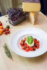 Plate with fresh salad with tomatoes, basil leaves and mozzarella 