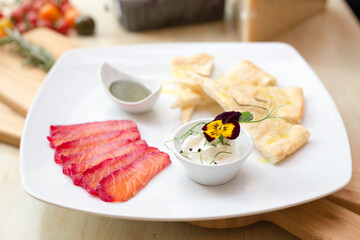 Salomon with focaccia on wooden board in restaurant