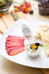 Salomon with focaccia on wooden board in restaurant