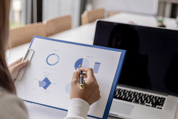 Businesswoman checking company financial documents, financial information sheet provided by finance department, bringing financial information to meetings with partners. Finance concept.