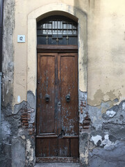 Porta in legno vecchia e usurata tipica di un paesino di mare e di pescatori in Sicilia