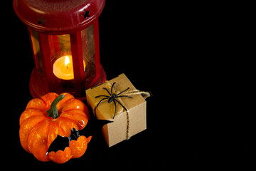 Halloween. Festive autumn decorations. Lantern, pumpkin, bat and gift box on a black background. Decor concept for halloween celebration. Copy space. - 454974448
