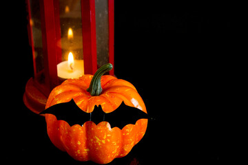 Halloween. Festive autumn decorations. Lantern, pumpkin and bat on a black background. Decor concept for halloween celebration. Copy space. - 454974457