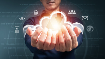 The concept is A Big data analytics and business intelligence with graph chart icons, cloud computing on a digital versual screen interface, and a man in the background blur.