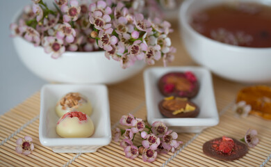 A cup of tea and sweets on the table with flowers