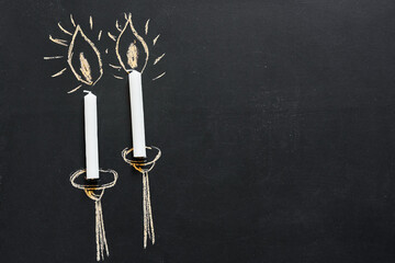 Two candles painted on a chalkboard with copy space.