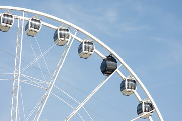 Closeup of gondola of a ferry wheel with a clear blue sky
