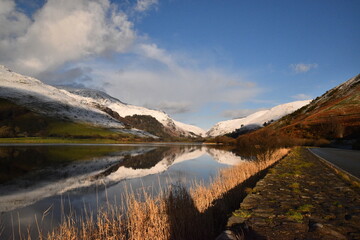 the still waters of tal-y-llyn lake with the snow covered welsh mountain tops reflected in its waters